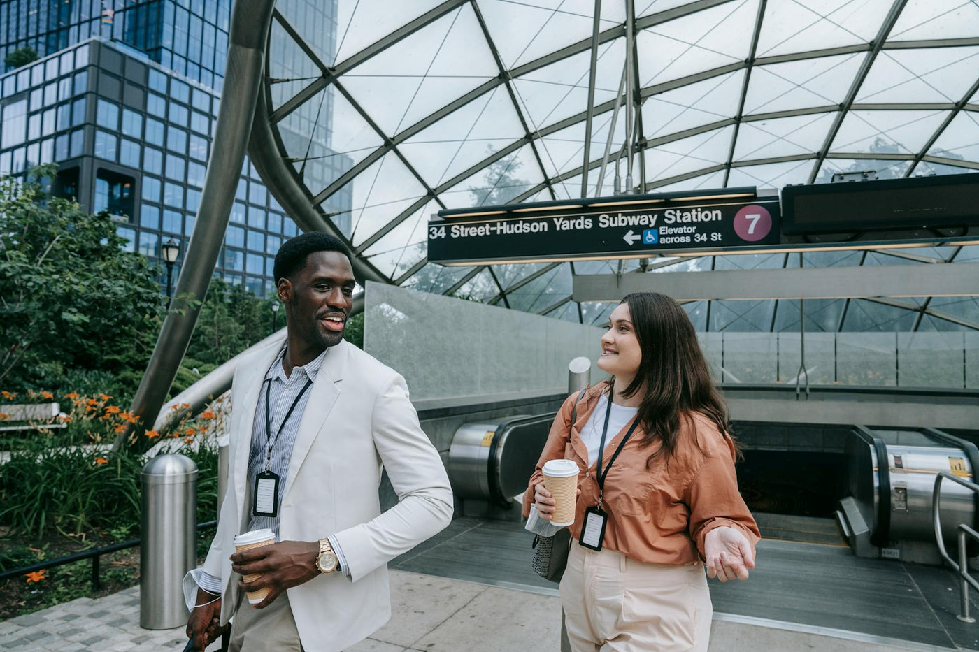 Two professionals engaged in conversation at 34 Street-Hudson Yards subway station in New York City.