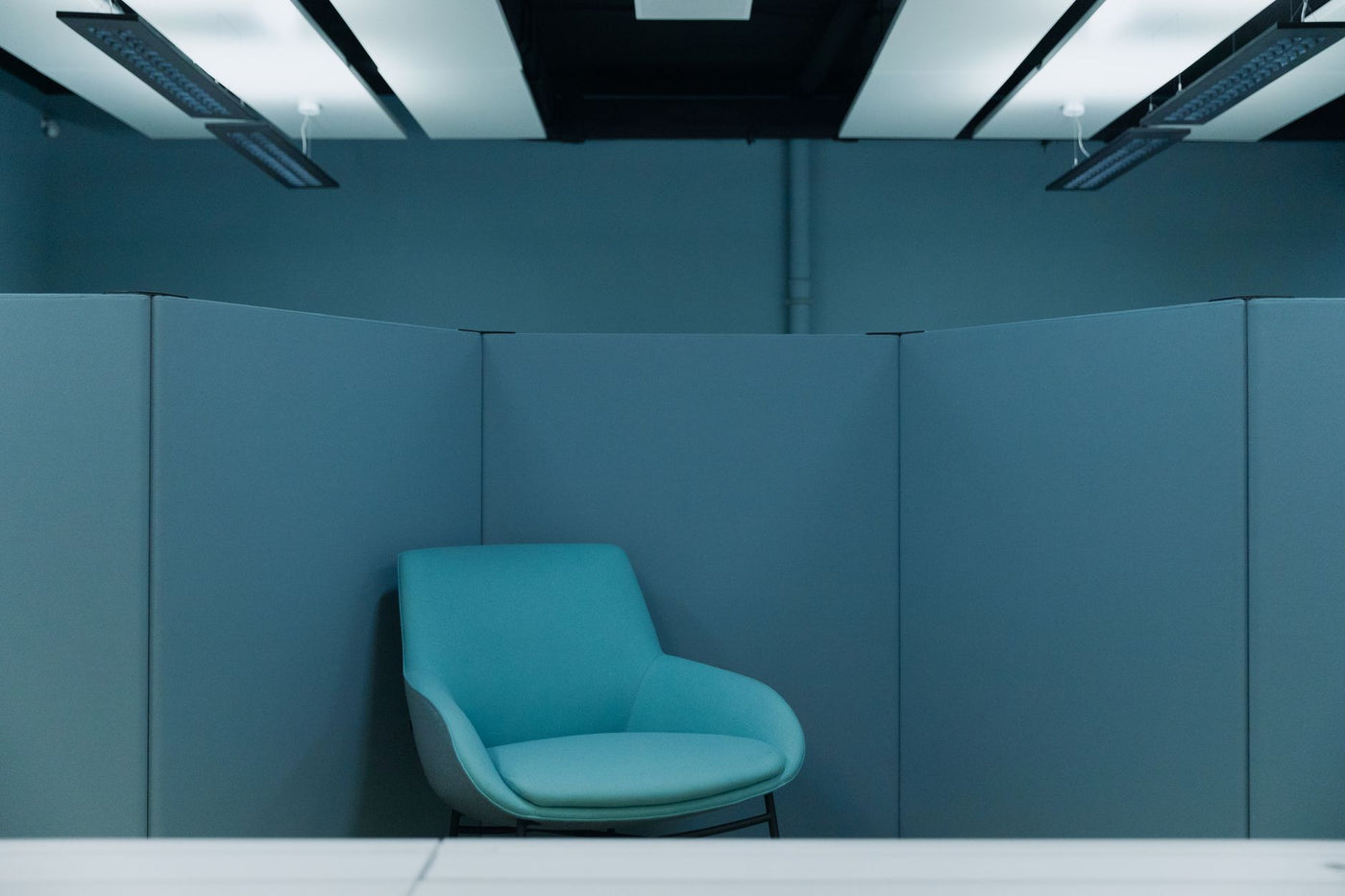A serene office space featuring a stylish blue chair in a minimalist environment.