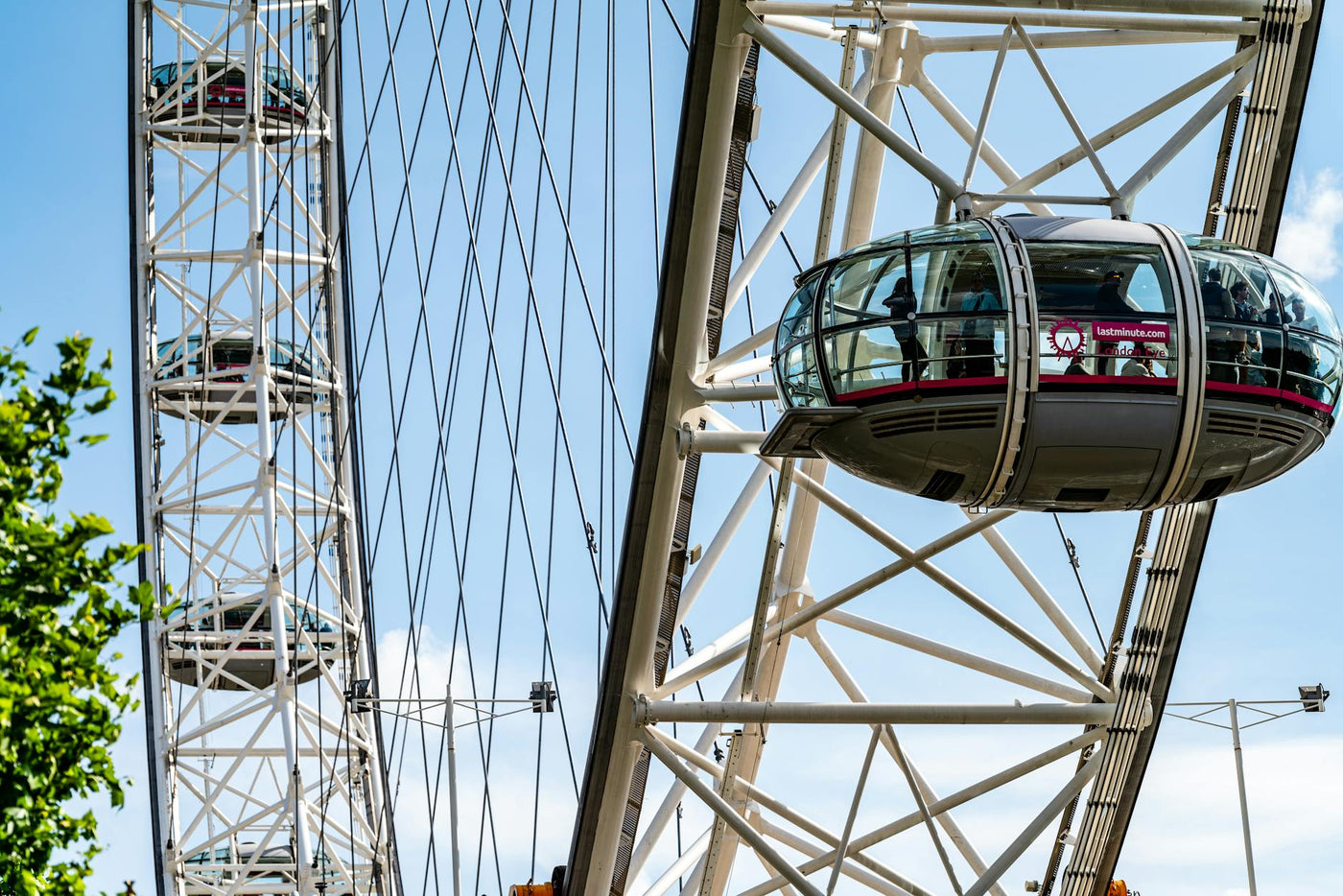 A detailed view of a capsule on the London Eye against a bright blue sky.