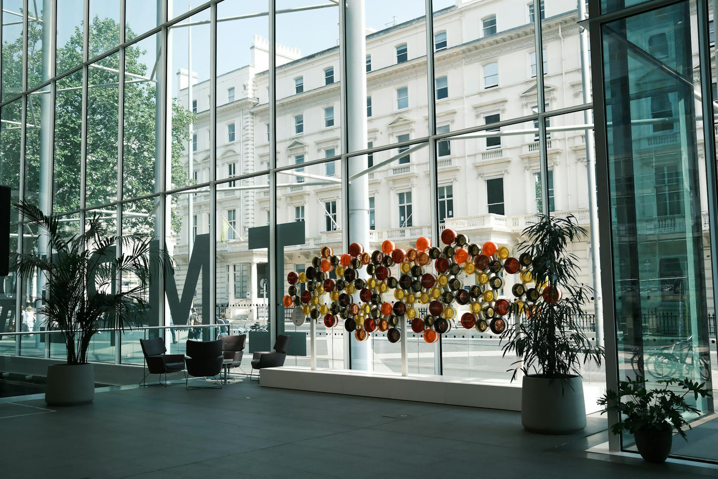 Spacious lobby with colorful art installation and large windows overlooking cityscape.