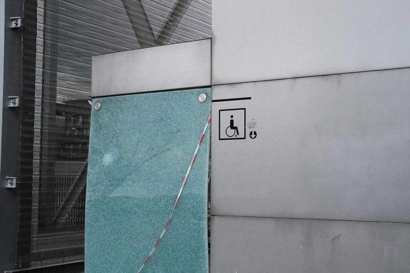 Urban architectural facade featuring an accessibility symbol for wheelchair access.