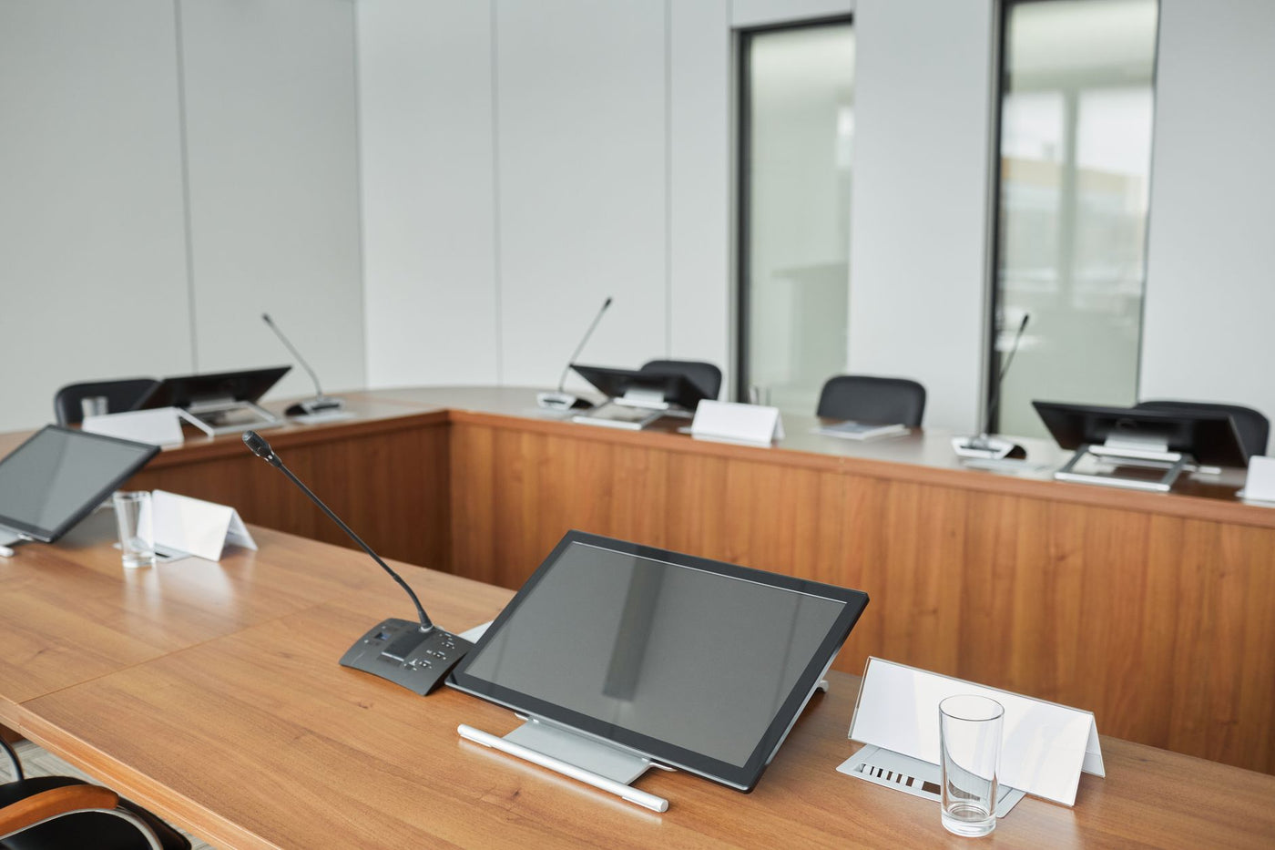 Spacious conference room equipped with modern technology and microphones for meetings.