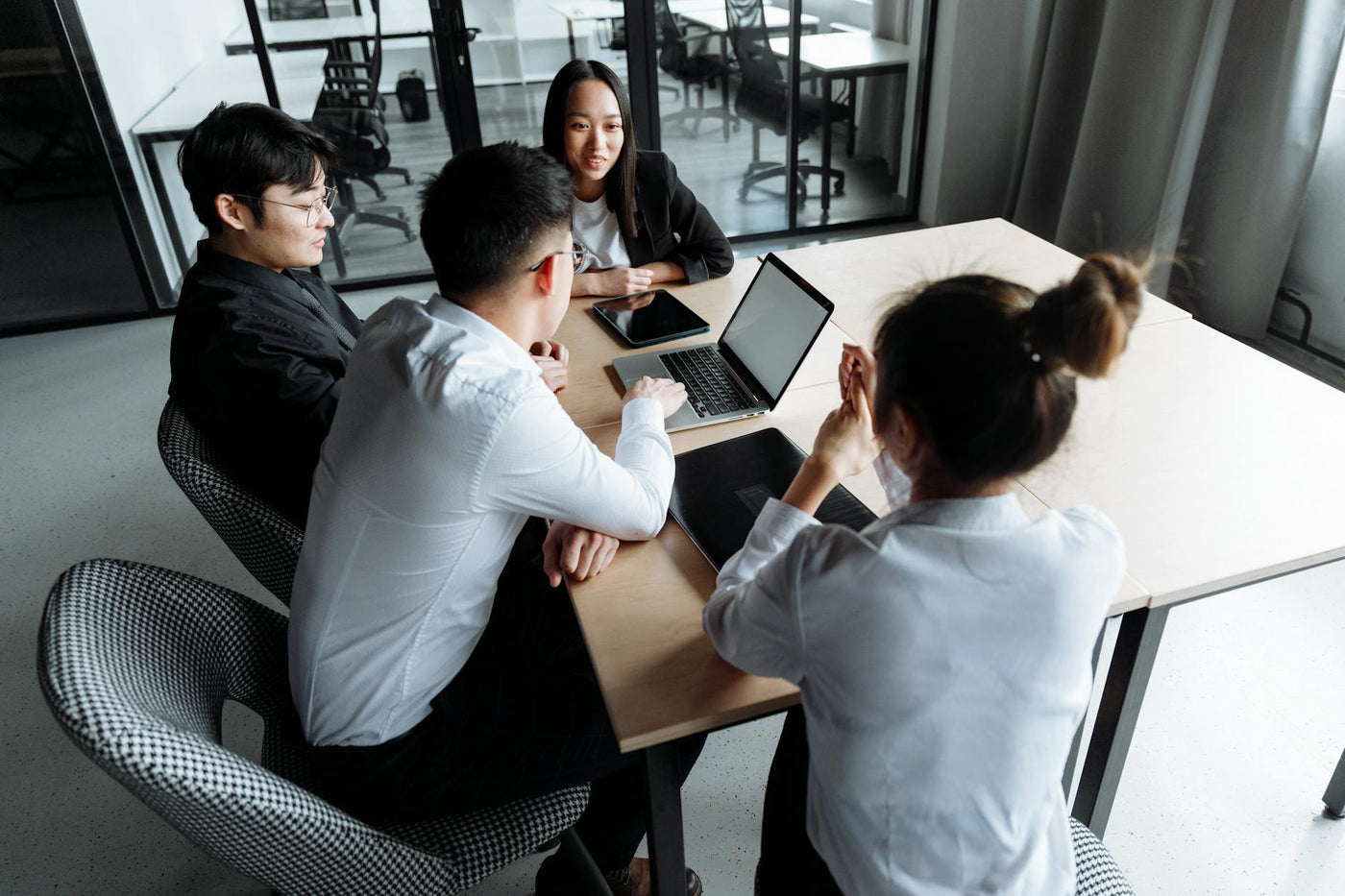 Dynamic team of professionals collaborating around a table in a modern office setting, fostering innovation.