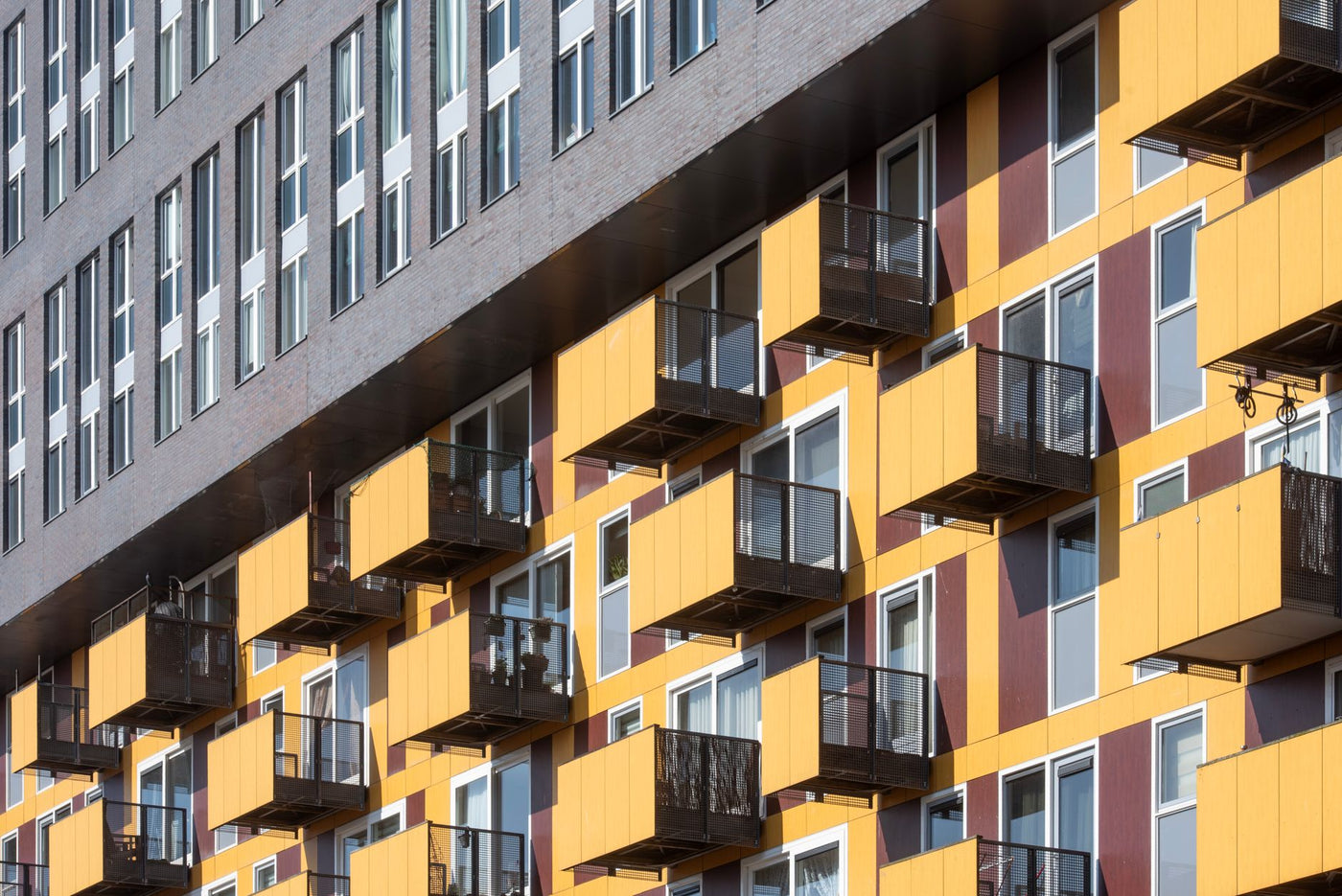 Contemporary architecture featuring bold yellow balconies of a city apartment building.
